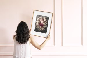 Woman holding picture frame mockup psd